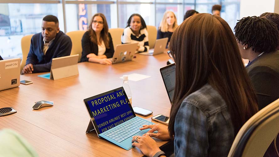 Young employee using SuperNova Magnifier on a laptop in an office meeting